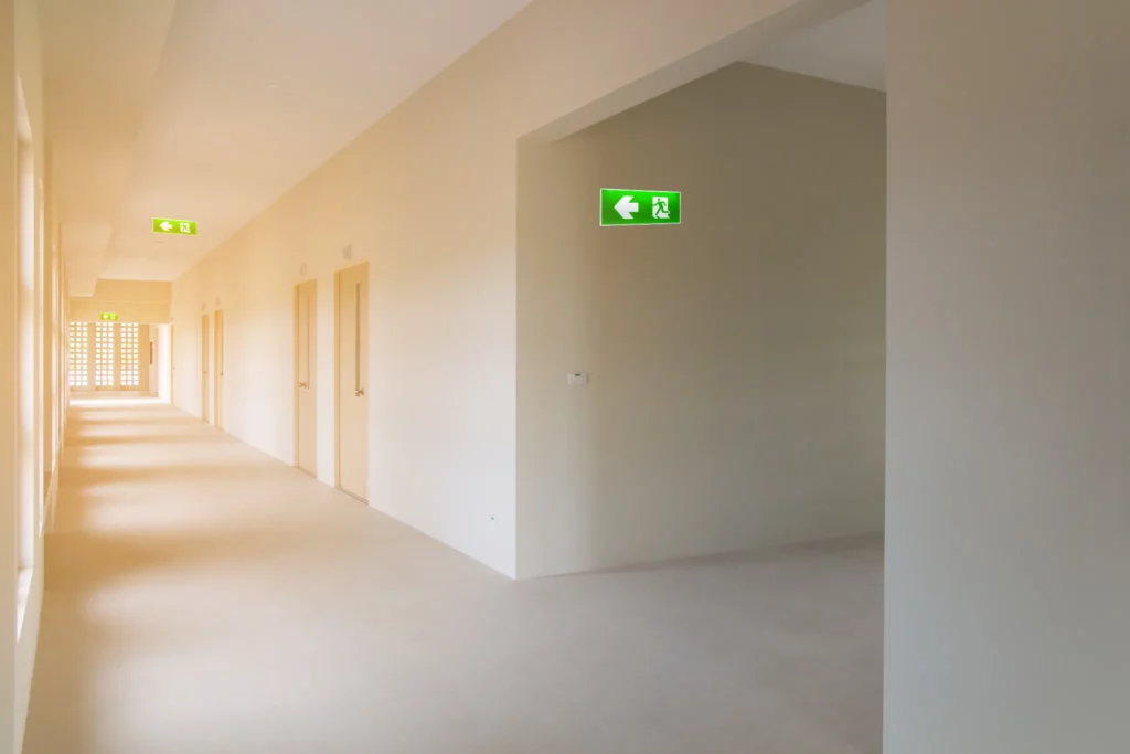 Couloir enfumé d'entreprise avec panneaux de sortie de secours