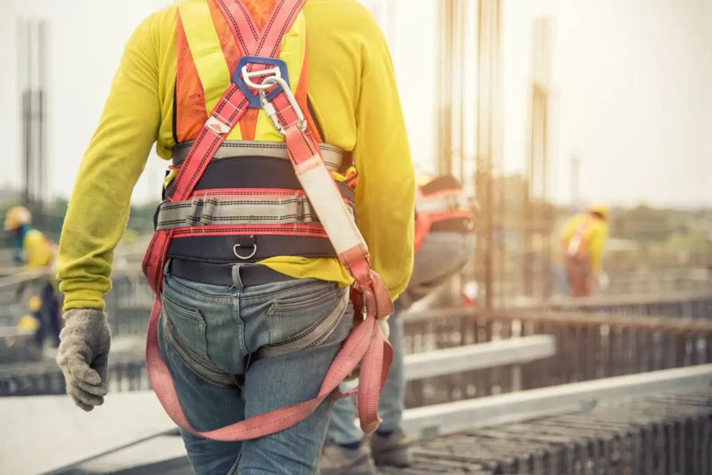 Travailleur en hauteur équipé d'un harnais de sécurité sur un chantier de construction